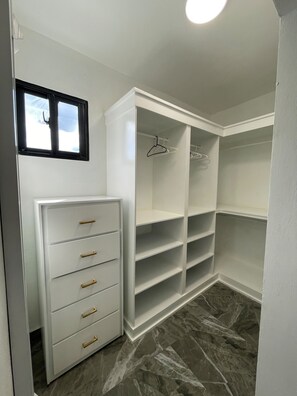 A walk-in closet with white cabinetry, a small window, and a marble floor. - 3-bedroom house in wonderful Bonao with big pool (Bonao)