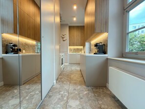 A modern kitchen with built-in appliances, a central island, and a window with a view. - Poniatowskiego Signature Apartment (Wrocław)