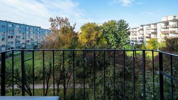 A balcony with a view of a residential area, including apartment buildings and a park.
