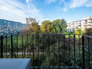 A balcony with a view of a residential area, including apartment buildings and a park. - Maratońska Standard Apartment (Łódź)
