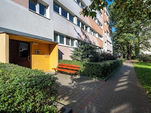 Ein Weg zu einem Gebäude mit einer Bank und Grünflächen.