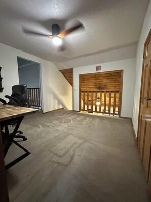 A room with a ceiling fan, a wooden door, and a window with a wooden railing. - 4 Bedroom Private Mountain Home Near Golden, Boulder, Eldora Ski Resort (Golden)