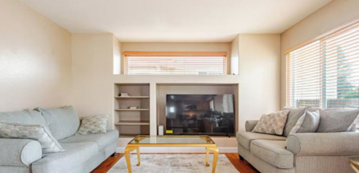 A living room with two sofas, a coffee table, and a TV.