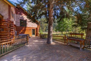 A log cabin with a deck and a fenced area. - NEW | Private Hot Tub | Hike | Gallatin Canyon, Fire Pit, Sleeps 12 (Gallatin Gateway)