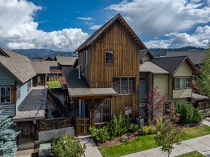 A wooden house with a sloped roof, a visible chimney, and a small porch area. - New! Private Hot Tub | Town Center | Sleeps 9 (Big Sky)