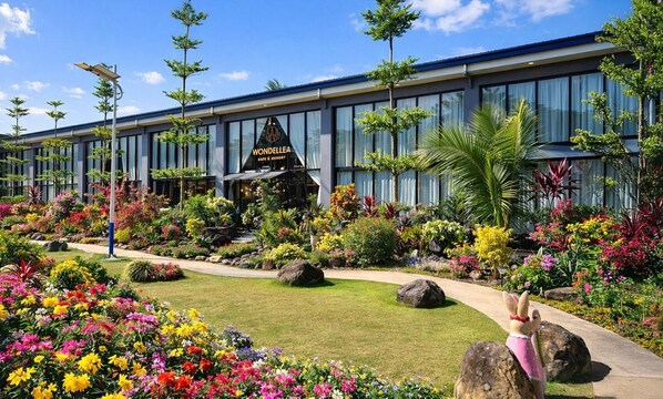 A modern building with a garden in front, including a sign for 'Wondellea Cafe & Restaurant'.