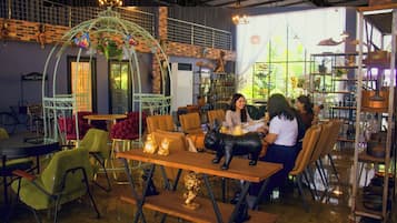 Un comedor interior con mesas redondas, sillas y elementos decorativos.