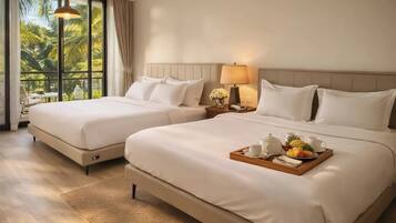 A hotel room with two beds, a dining table with breakfast, and a view of palm trees.