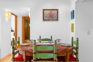 A dining area with a round wooden table, green chairs, and a colorful woven table runner. - Casita Espléndida 2 Blocks from the Beach (Puerto Vallarta)