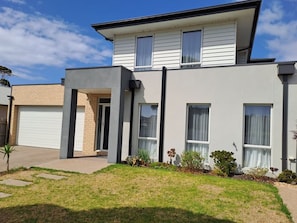 A modern two-story house with a garage, a covered patio, and a well-maintained lawn. - Rosebay Walk To The Foreshore (CAPEL SOUND)