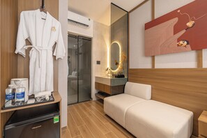 A hotel room with a bed, a bathroom with a mirror, a robe hanging, and a coffee maker on the side table. - ALIX Hotel By An Gia Hospitality (Ho Chi Minh City)