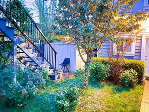 A residential garden with a staircase, a shed, and a chair. - V-2BR Laneway - 15 Mins To DownTown (Vancouver)