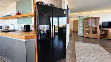 Una cocina moderna con un refrigerador negro, una cafetera y una encimera de madera.