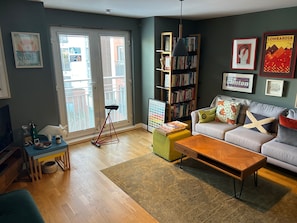 A living room with a sofa, coffee table, and a bookshelf. - One Double Room in Holyrood Apartment (Edinburgh)