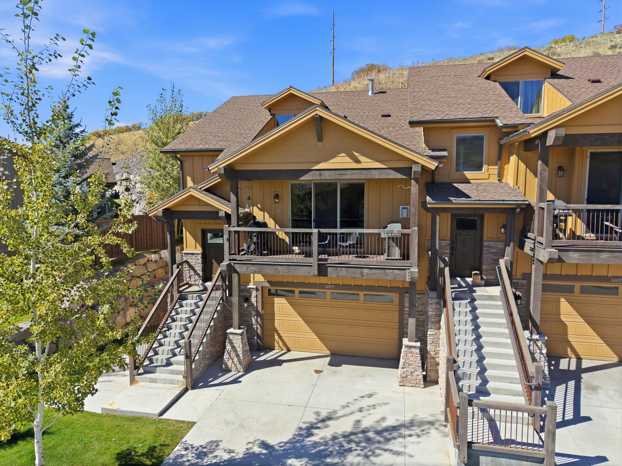 A two-story house with a front porch, a garage, and a staircase leading to the entrance.