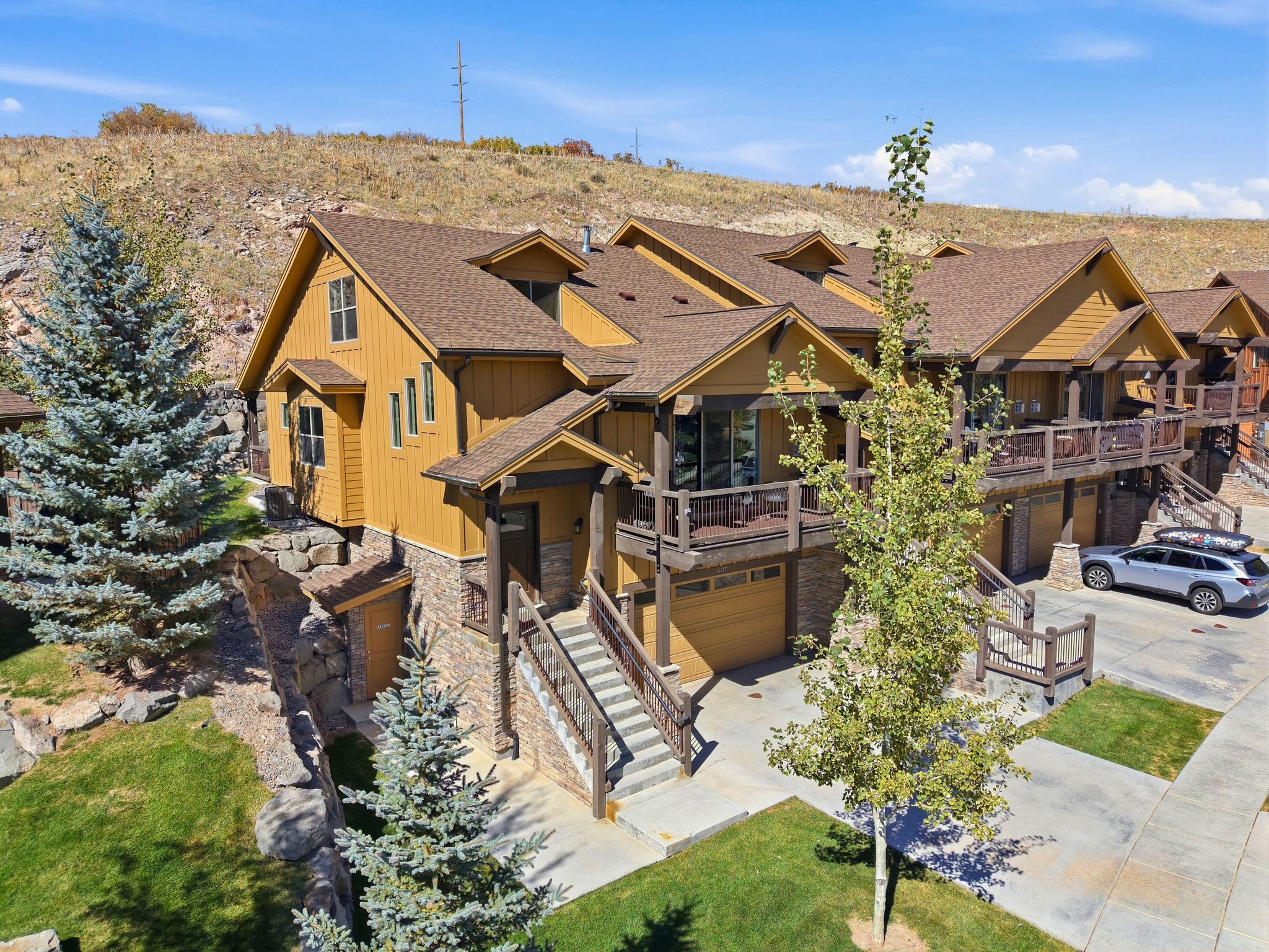 A multi-story resort with wooden cabins, a central building with a balcony, and a parking area.