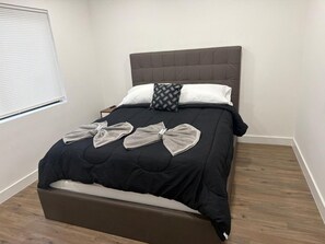 A bed with a headboard, a bedside table, and a window with blinds. - Newly Renovated 1BR | Near Beach & Downtown #3 (Hollywood)