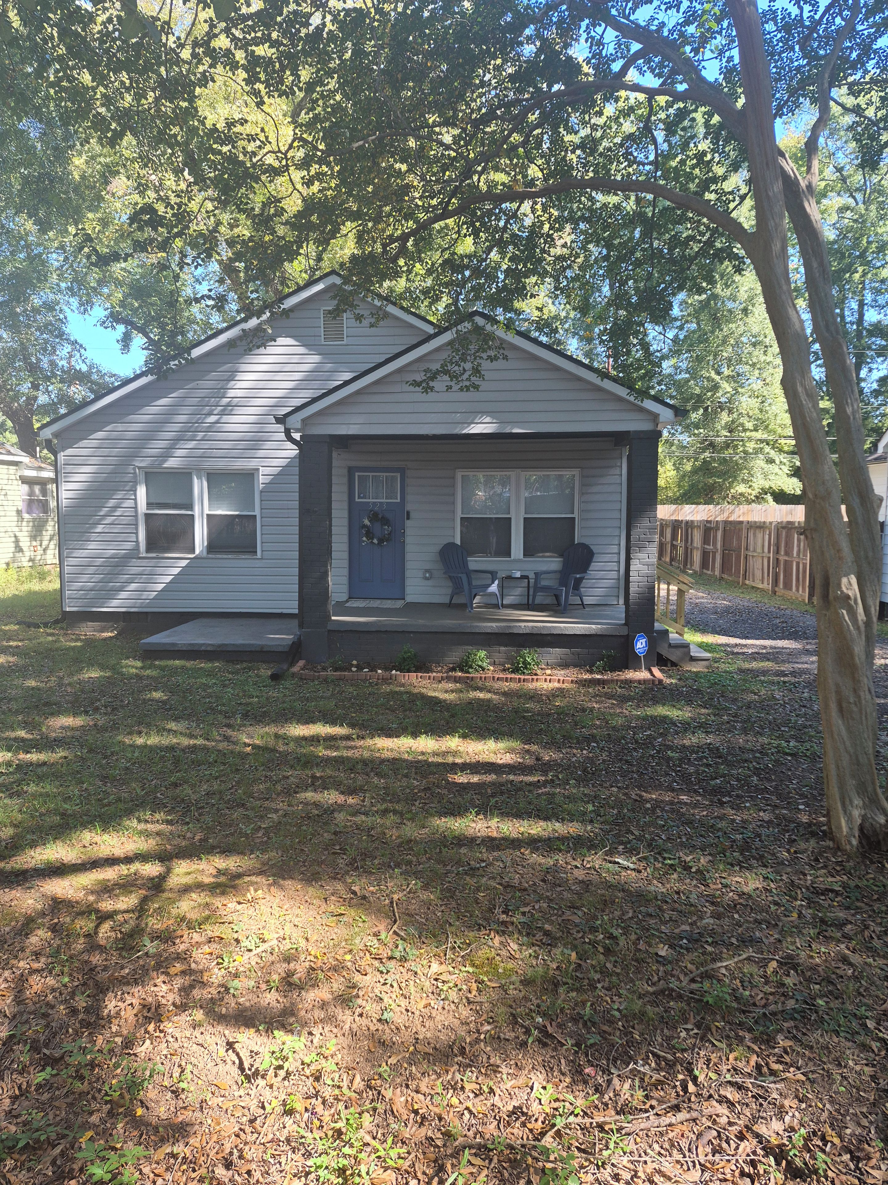 A single-story house with a porch, a front door, and a small window.