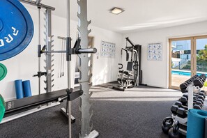 A gym with weightlifting equipment, exercise machines, and dumbbells. - Alpine Retreat | 2-Bedroom Apartment with Pools, Hot Tub, Gym & Resort Facilities (Wānaka)