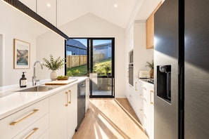 Cook, gather, and enjoy every moment in this beautifully designed kitchen. ✨ Featuring premium appliances, generous bench space, and a bright, modern finish, it’s fully equipped for everything from morning coffee to family dinners in Wānaka. - Modern Wānaka Retreat | 3 Queen Bedrooms, Mountain Views, High Ceilings & Internal Garage (Wānaka)
