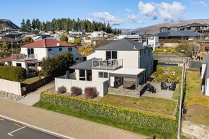 A modern residential area with houses featuring flat roofs, solar panels, and a well-maintained garden. - Mountain View House | 3 Bedrooms, Sleeps 6, 2 Bathrooms, Air Conditioning & Easy Access to Lake Wānaka (Wānaka)