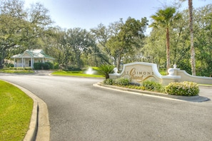 A road leading to a building with a sign that reads 'St. Simons Grand'. - Enjoy Endless Views  at Beachfront Condominium! (St. Simons Island)
