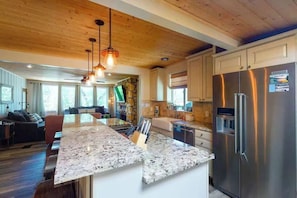A modern kitchen with granite countertops, stainless steel appliances, and a wooden ceiling. - Paradise Cove - Lake View, Dock, Near Yosemite (Bass Lake)
