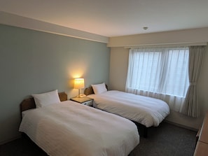 A hotel room with two beds, a nightstand with a lamp, and a window with curtains. - Smile Hotel Kagoshima-chuo Ekimae (Kagoshima/Nishida)