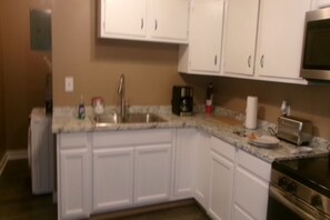 A kitchen with white cabinets, a stainless steel sink, a microwave, and a toaster. - 3 bedroom one bathroom in High point N.C. near HPU, (High Point)