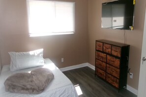 A bedroom with a bed, a dresser, a window, and a wall-mounted TV. - 3 bedroom one bathroom in High point N.C. near HPU, (High Point)