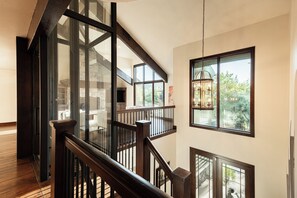 A multi-level interior with a wooden staircase, glass railings, and a view of the outdoors. - 4BR Park Meadows townhome with mountain views, sleeps 10 (Park City)