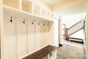 A hallway with a bench, a coat rack with hooks, and a staircase leading to another room. - 4BR Park Meadows townhome with mountain views, sleeps 10 (Park City)