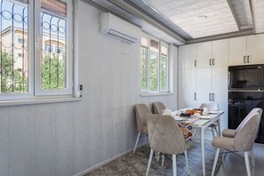 A dining area with a table, chairs, and a refrigerator. - Apartments in the historic center (Tashkent)