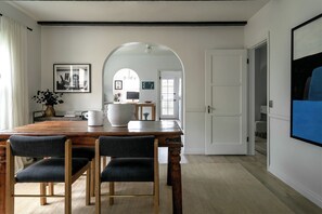 A dining area with a wooden table, four chairs, and a large white bowl. - Casa Mika - Designer Curated 2BR/1BA Retreat Near SoFi, Intuit Dome & The Forum (Los Angeles)