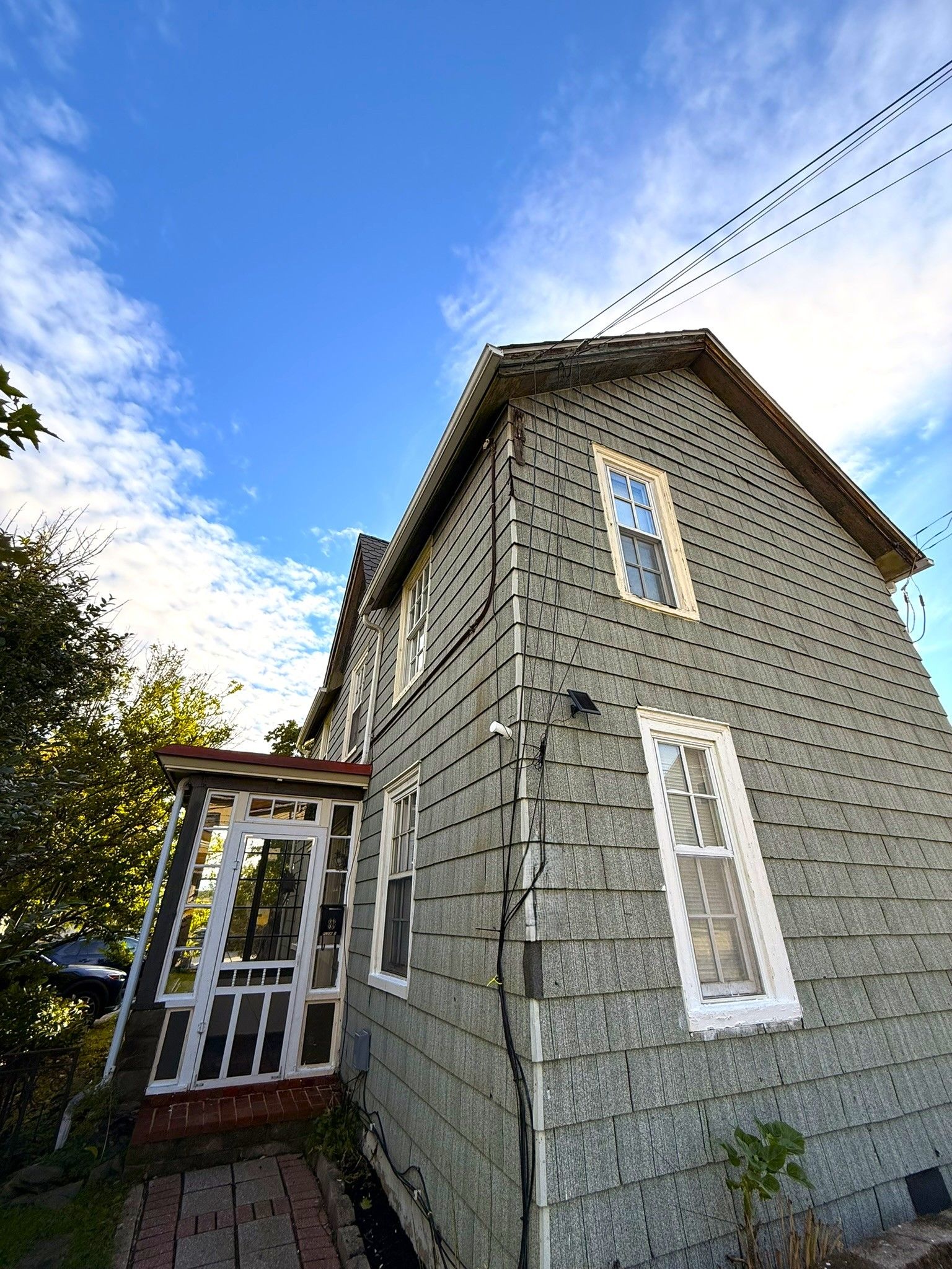 A two-story house with a gabled roof and a front porch.