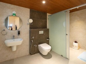 Un baño moderno con lavamanos, espejo, inodoro y zona de ducha.