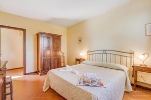 A bedroom with a bed, a wooden wardrobe, a desk, and a nightstand with a lamp. - Chianti Site Apt Fontana Shared Pool|4, Castelfiorentino, Italy (Castelfiorentino)