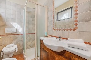 A bathroom with a glass-enclosed shower, a sink with a mirror above it, and a toilet. - Chianti Site Apt Fontana Shared Pool|4, Castelfiorentino, Italy (Castelfiorentino)