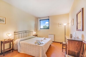 A bedroom with a bed, bedside tables, a dresser, a window with a view, and a radiator. - Chianti Site Apt Fontana Shared Pool|4, Castelfiorentino, Italy (Castelfiorentino)