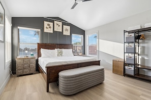 Ein Schlafzimmer mit einem großen Bett, einer Bank, einem Schminktisch und einem Regal.