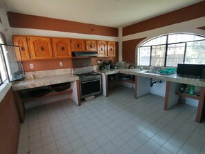A kitchen with wooden cabinets, a stove, and a sink. - Country Cottage in Morelos · Private Pool · Pet-Friendly (Fraccionamiento Paraíso Tlahuica)