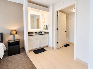 A hotel bathroom with a sink, mirror, and a towel rack. - Dallas Stay | Pool + Gym | Near Love Field & UTSW (Dallas)