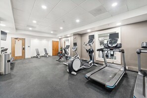 A gym with treadmills, elliptical machines, and weight benches. - Dallas Stay | Pool + Gym | Near Love Field & UTSW (Dallas)
