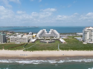 A beachfront hotel with a central courtyard, multiple floors, and a view of the ocean. - Sunchase IV #312 - Beachfront Resort, Pools & Balcony (South Padre Island)