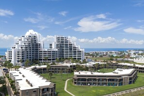 Hotel de diverses plantes amb un disseny arquitectònic modern, amb balcons i vista a l'oceà.