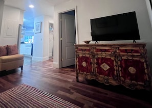 A living room with a flat-screen TV on a wooden cabinet, a sofa, and a patterned rug. - Live Like a Local in this Spacious Ground Level Condo -close to Dining & Skiing❄️ (Edwards)