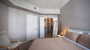 Ein Schlafzimmer mit Bett, Stuhl, Kleiderschrank und Spiegel.