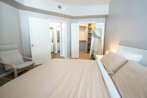 A bedroom with a bed, a chair, a closet, and an open door to a bathroom. - Cozy 1-bedroom apartment in Marina del Rey (Marina del Rey)