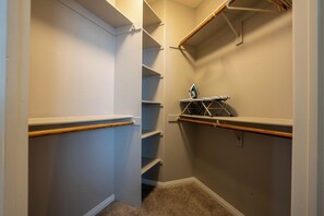 A walk-in closet with open shelving, a hanging rod, and a small ironing board. - Cozy 1-bedroom apartment in Marina del Rey (Marina del Rey)