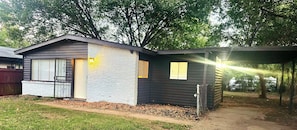 A small, single-story building with a gabled roof, a front door, and a small porch area. - Modern Tulsa Retreat  Stylish 3BR Home Near Downtown & Local Attractions (Tulsa)
